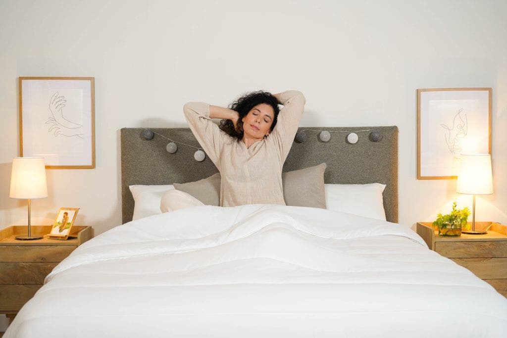 Mulher a esticar-se na cama